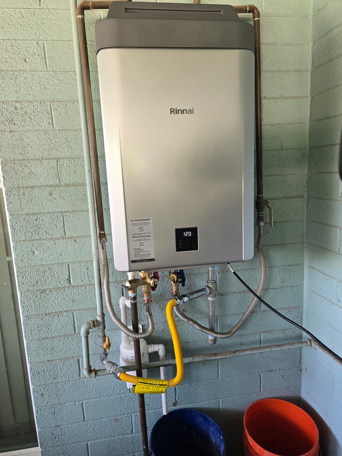 Rinnai tankless water heater installed on a block wall by Western Sky Plumbing, an Authorized Rinnai Pro in Phoenix